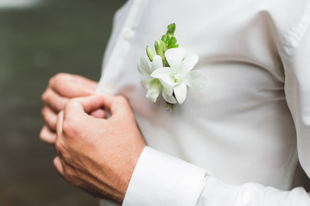 Groom boutonniere with white orchids on white shirtの写真素材
