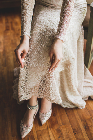 Bride wearing silver metal adornment bracelet on feet, beautiful beige lace dressの写真素材
