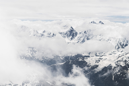 Panoramic view of high mountain peaks in snowy and foggy cold weather. Hiking and climbing in Elbrus regionの写真素材