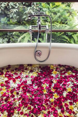 Bath tube with tropical flowers, spa, relaxation, body care, therapy. Top viewの写真素材