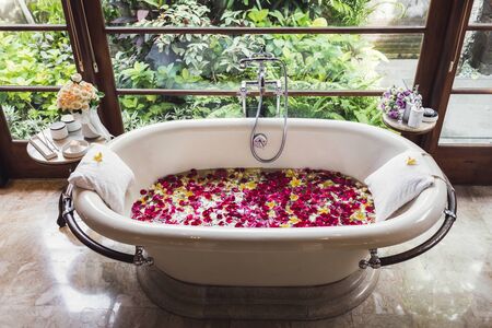 Bath tube with tropical flowers, spa, relaxation, body care, therapy. Top view