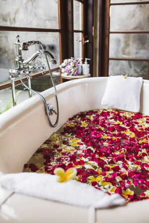 Bath tube with tropical flowers, spa, relaxation, body care, therapy. Top viewの写真素材
