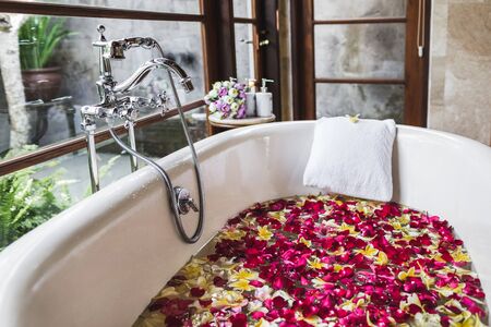 Bath tube with tropical flowers, spa, relaxation, body care, therapy. Top viewの写真素材