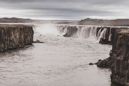 Dramatic view of Selfoss waterfall in cold and gray autumn weather. Amazing nordic landscape....