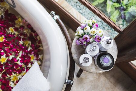Bath tube with tropical flowers, spa, relaxation, body care, therapy. Top viewの写真素材