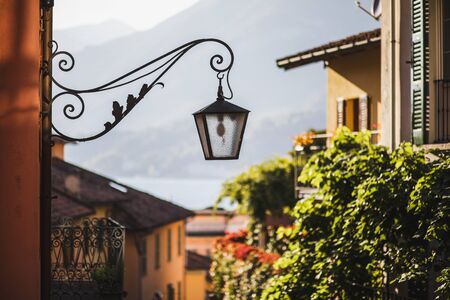 Old metal forged lantern on cozy european street. Old city architecture details.Summer in Italy.の写真素材