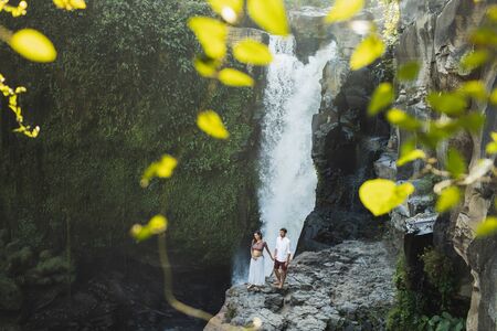 Couple travel in pregnancy. Amazing view of Tegenungan Bali cascade waterfall landscape. Morning sunlight, wanderlust conceptの写真素材