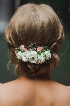 Classic and simple bridal hairstyle with white and pink rose flowers. View of hairdo from behind closeup.の写真素材