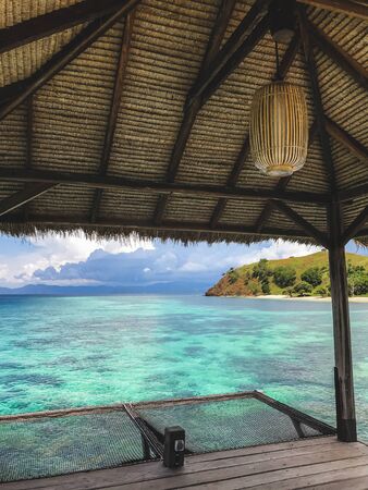 View of tropical island with turquoise transparent clear water from wooden pier. Vacations concept. Luxury island resort.の写真素材