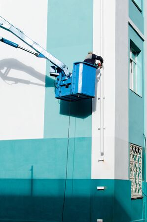 worker on the lift to mount the pipe on a buildingの写真素材