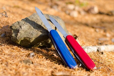pocket knives on a stoneの写真素材