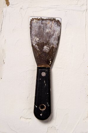 a vintage putty knife on the background of putty