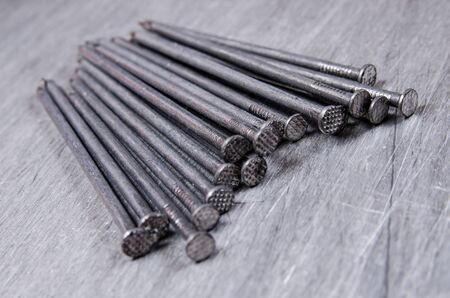 a bunch of metal nails on the alluminium scratched backgroundの写真素材