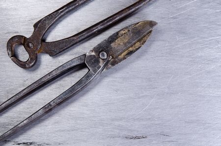 scissors for metal and pincers lay on a sheet of alluminium. vintage.の写真素材