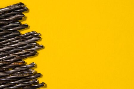 a lot of drills of different sizes on a bright yellow backgroundの写真素材