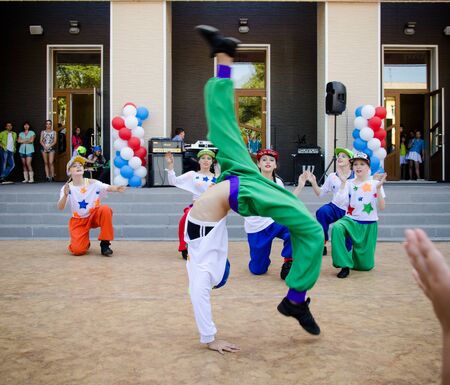 Komsomolsk-on-Amur, Russia, August 1, 2015. Railroader's day. A girl in a hip hop costume makes a somersault while dancing on a street scene.のeditorial素材