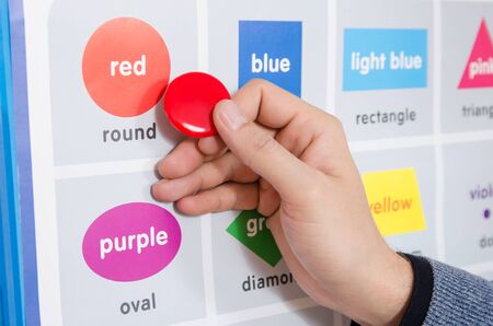 a male educator explains the spelling of the word red on the training table in the training room