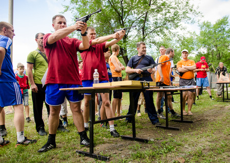 KOMSOMOLSK-ON-AMUR, RUSSIA, AUGUST 1, 2015. Public open Railroader's day. The shooting competition for men in the amateur category. two men shoot from pneumatic pistol in competition.のeditorial素材