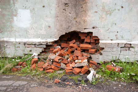a broken wall from which the bricks fell out. the concept of urgent repair.の写真素材