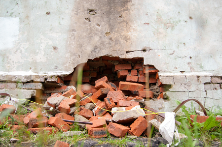 a broken wall from which the bricks fell out. close up. the concept of urgent repair.の写真素材