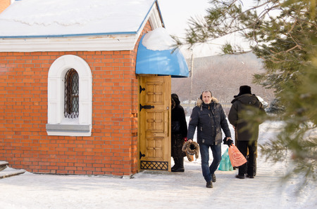 Komsomolsk-on-Amur, Russia - January 19, 2018. Public open. Cathedral of the Kazan Icon of the Mother of God, Epiphany. People come out of the cathedral with blessed waterのeditorial素材