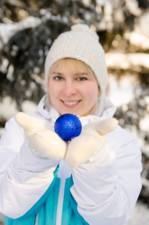 beautiful attractive blonde girl in sportswear holding a ball to decorate a Christmas tree.  vertical viewの写真素材