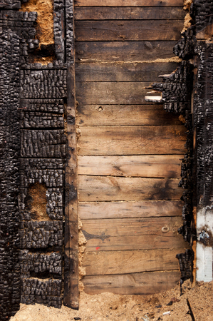 brown burnt wall of house of wooden planks with embossed texture. background for copy space. concept of loss of real estate or home. property insurance. verticalの写真素材