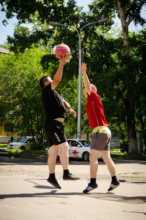 Komsomolsk-on-Amur, Russia - August 1, 2016. Public open Railroader's day. Young men play amateur basketball in summer. Low point shootingのeditorial素材