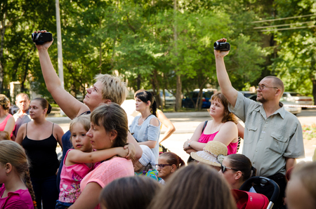 Komsomolsk-on-Amur, Russia - August 1, 2016. Public open Railroader's day. parents shoot a video of their children at the festivalのeditorial素材