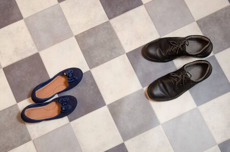 light and comfortable blue women's shoes and man's shoes on  black and white checkered floor.の写真素材
