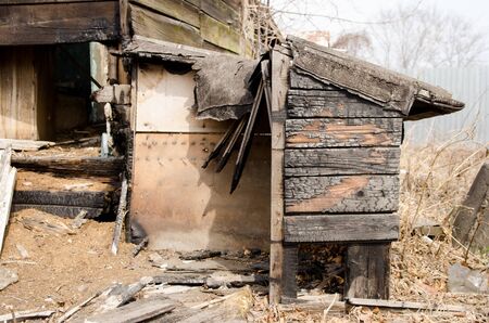 Brown and black burnt house of wooden planks with embossed texture without door and broken wall. 
damage to the building from fire without the possibility of its restoration. concept of loss of real estate or home. property insurance.の写真素材