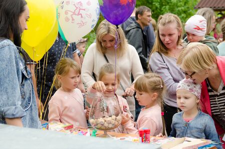 Komsomolsk-on-Amur, RUSSIA - SEPTEMBER 2, 2019. children play the lottery pulling tickets out of a glass bowl with tropical big bugsのeditorial素材