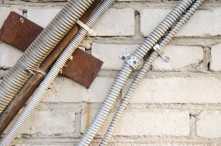 electric wires in a protective pipe on a brick wall. close-up.