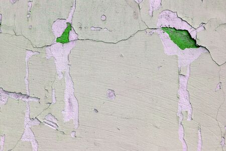 old weather-aged wall with crumbling plaster pistachio and green colors.