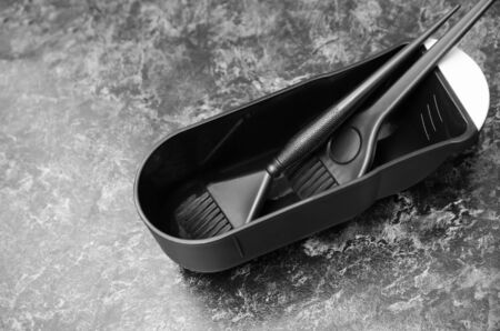 plastic black brushes for dyeing hair in an empty container for paint on the board.の写真素材