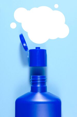 blue open shampoo bottle and balloon for text over it on a light blue background. vertical view.の写真素材