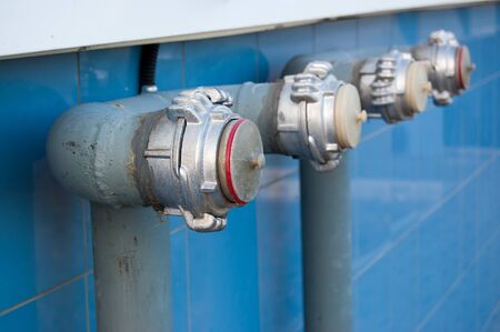 silver fire hydrants on the blue wall of the building.