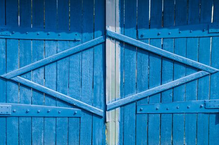 closed blue wooden vintage gate in the countryside.
