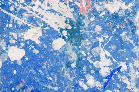spots and splashes of pink and white paint on a blue background. abstract pattern for decoration.