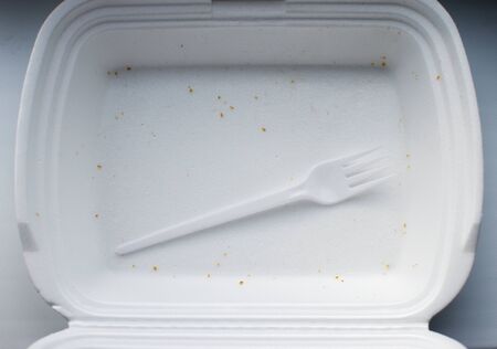 plastic fork in empty white foam box for food. view from above.の写真素材