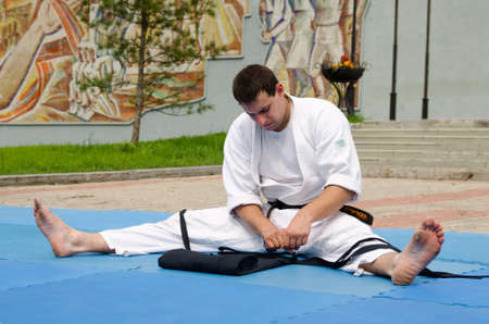 Komsomolsk-on-Amur, RUSSIA - JULY 21, 2018. Aikidoka man folds his hakama after a showのeditorial素材