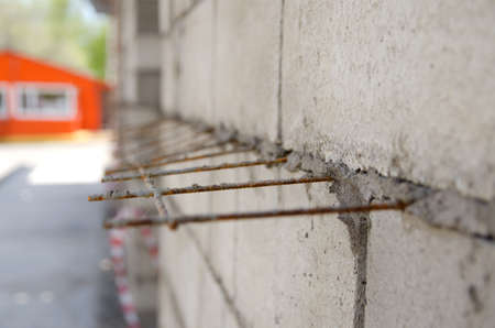 gray brick wall with iron bars reinforcement during construction.