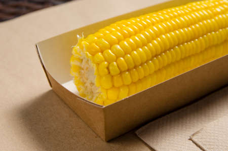 an ear of boiled corn in an eco-friendly cardboard box.