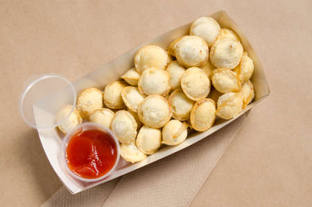 fried dumplings with red sauce in a cardboard box.の写真素材