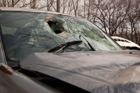 Broken windshield and crumpled hood of the car involved in an accident.の写真素材