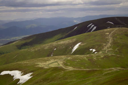 A large cloud shadow covers the mountain peak.