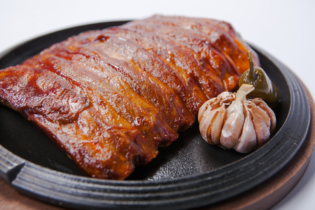 Tasty grilled ribs with vegetables in a dishの写真素材