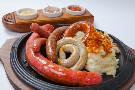 Assorted grilled sausages with mashed potatoes on a panの写真素材