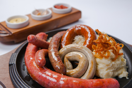Assorted grilled sausages with mashed potatoes on a panの写真素材