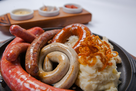 Assorted grilled sausages with mashed potatoes on a panの写真素材